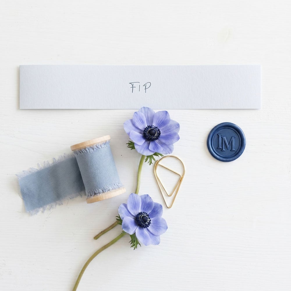 a selection of extras for a blue toile wedding suite, including belly band, ribbon, wax seals and teardrop paperclips
